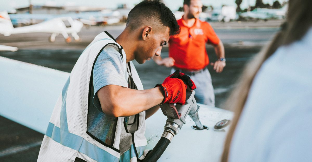 man fueling plane near man