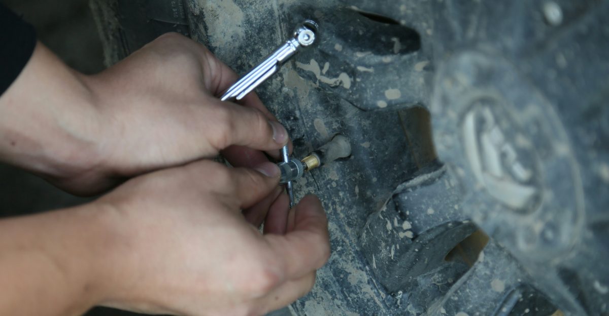 person putting on a pin on vehicle tire