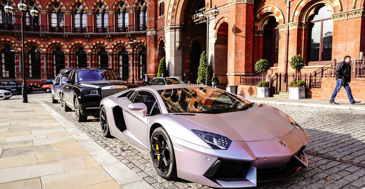 white porsche 911 parked near brown concrete building during daytime