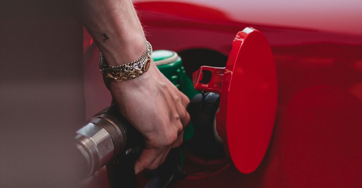 person in red shirt wearing silver bracelet holding red and black metal tool