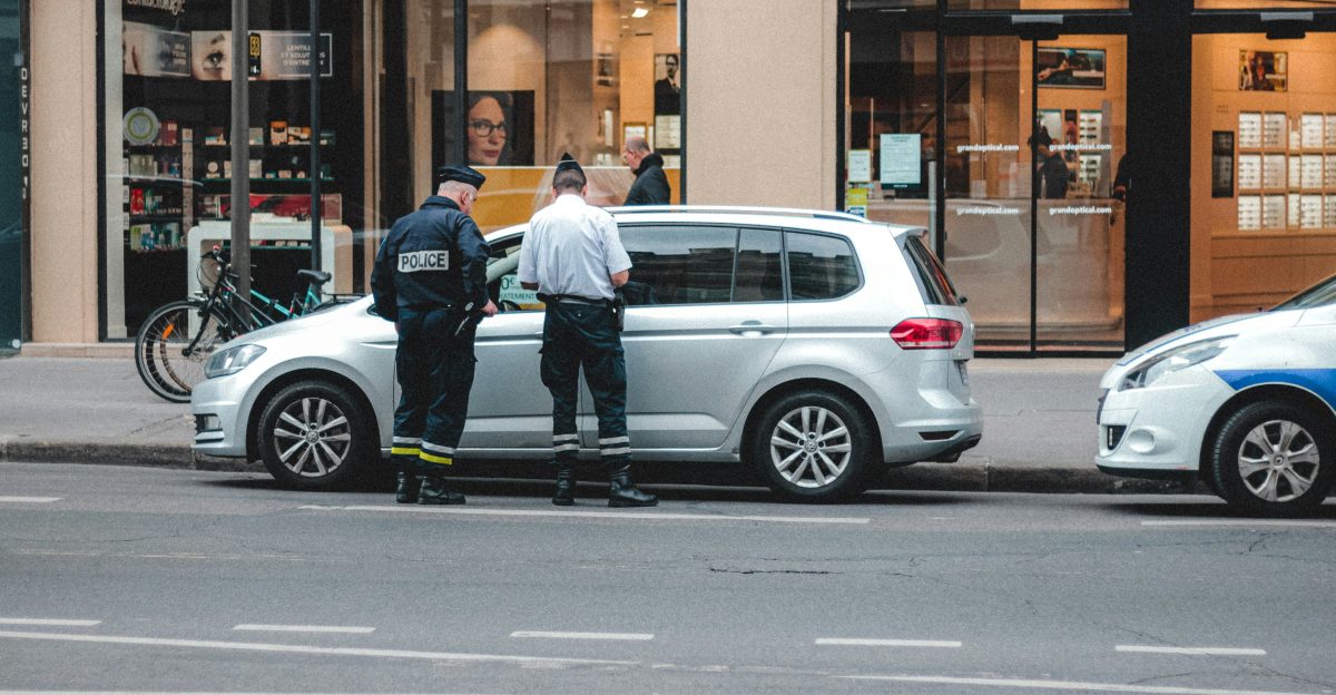 two police officers standing on the back of a car