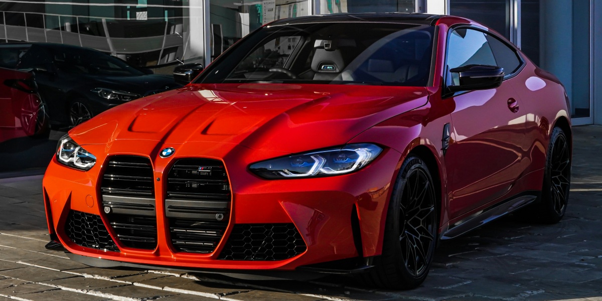 red bmw m 3 coupe parked on gray concrete pavement during daytime