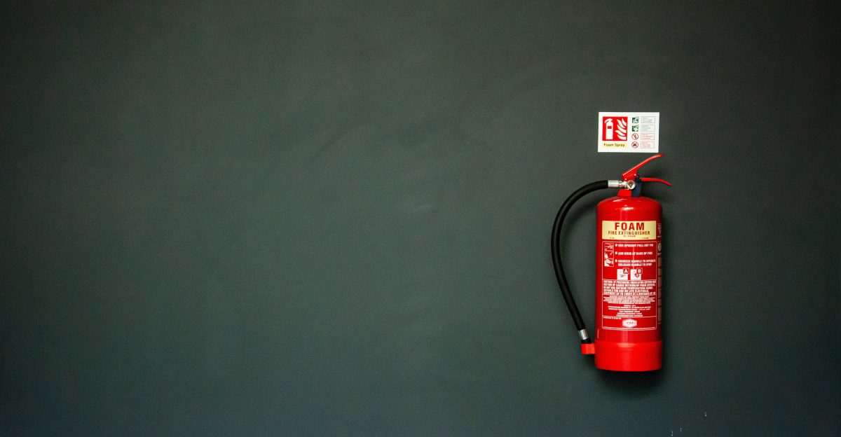 red fire extinguisher on gray wall