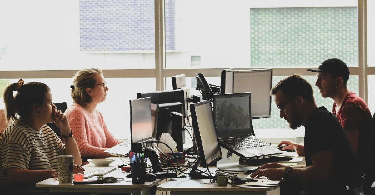 woman in pink shirt sitting in front of black laptop computer