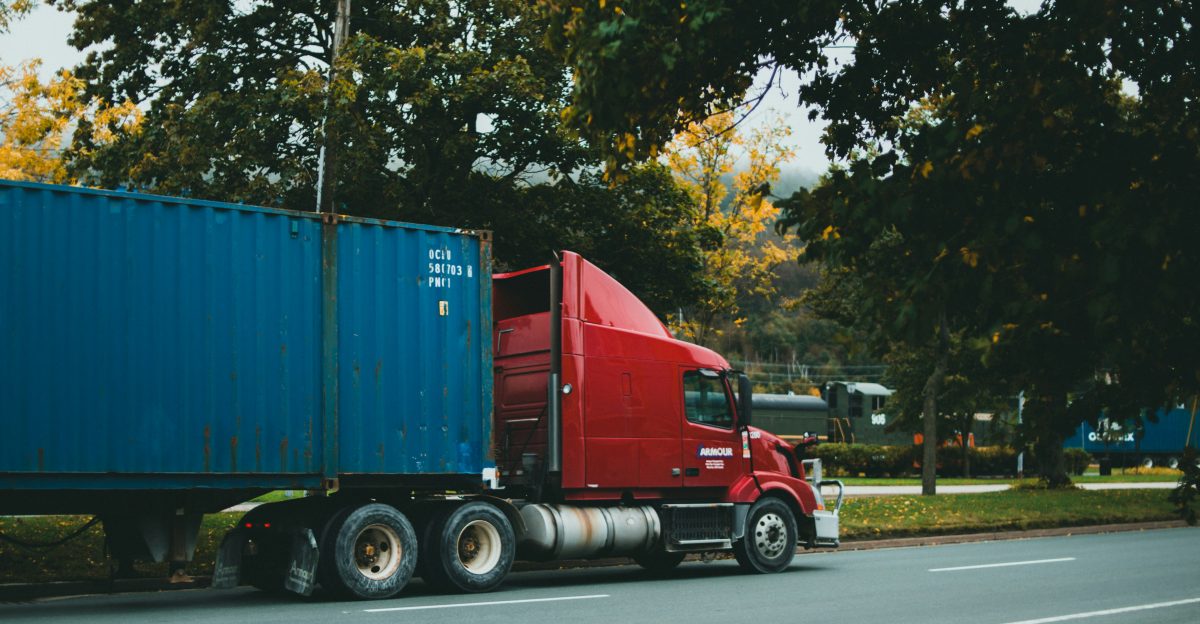 a red semi truck driving down a street