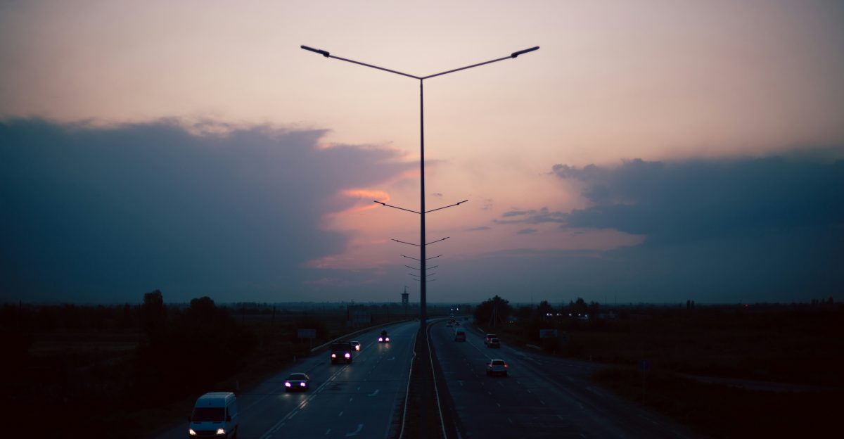 the sun is setting over a highway with traffic