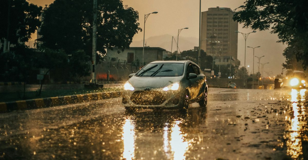 a car driving down a rain soaked street