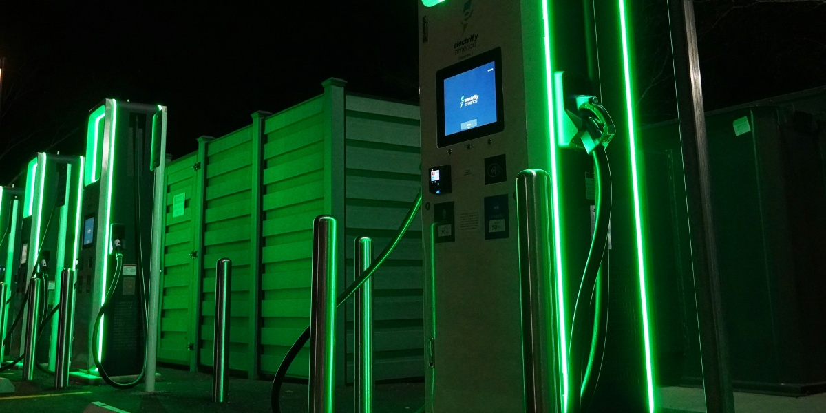 a row of green gas pumps at night