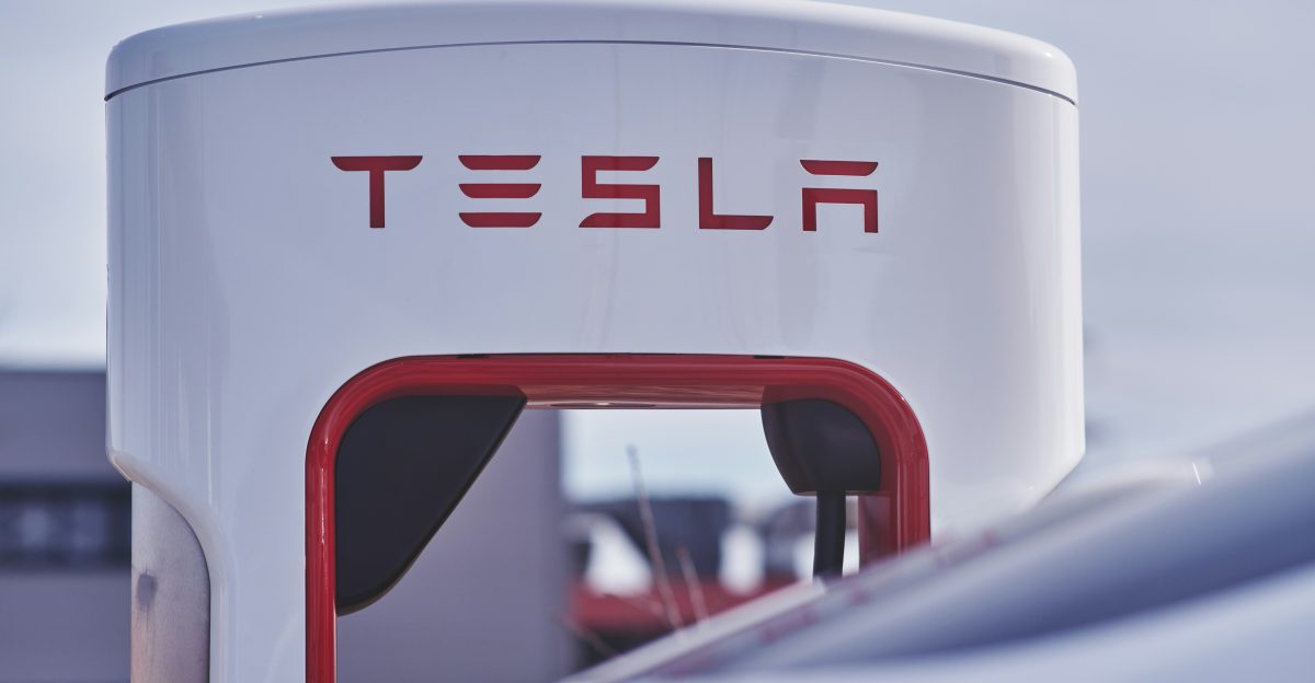 a close up of a white and red tesla gas station