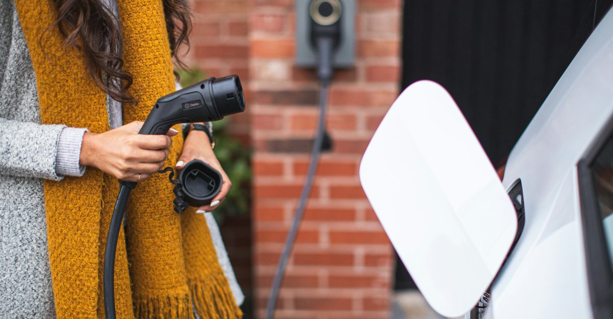 a woman is pumping gas into her car