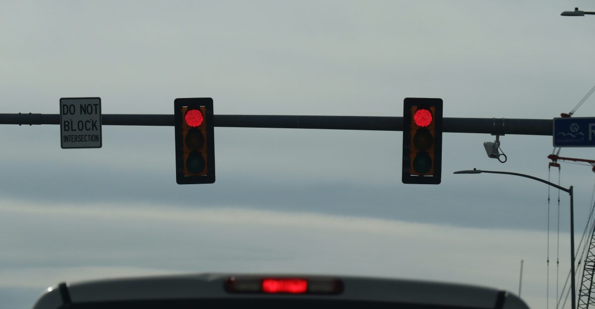 a couple of traffic lights hanging from a metal pole