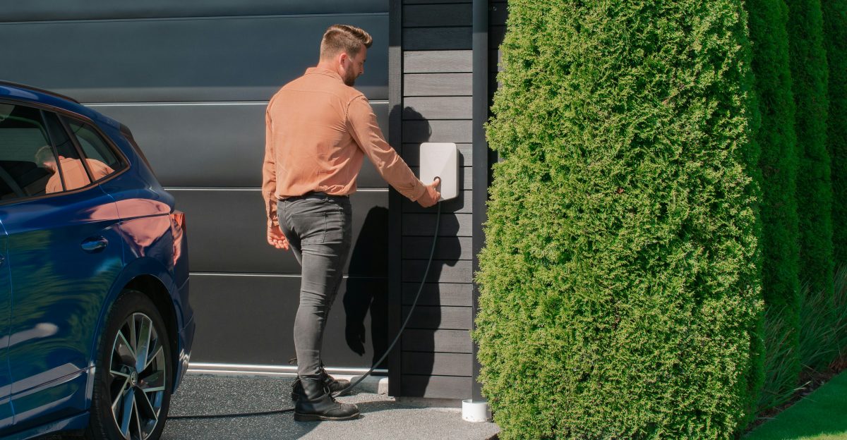 a man standing next to a blue car