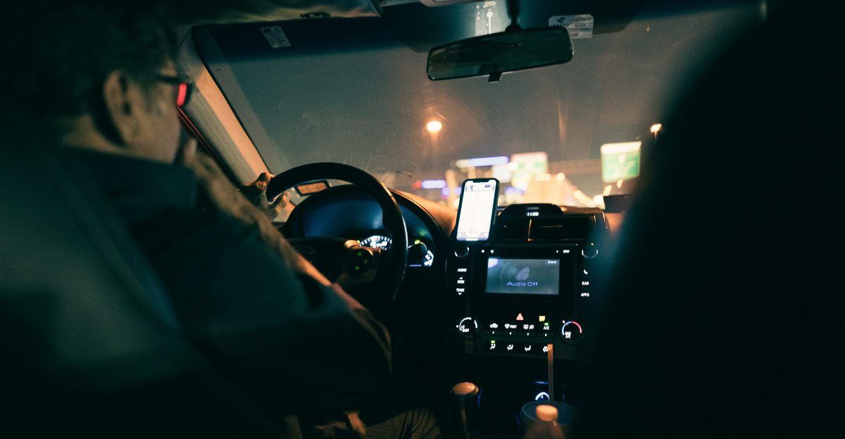 a man driving a car at night in the dark