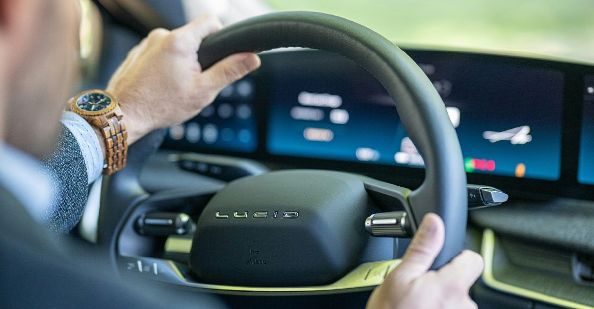a man driving a car with a steering wheel