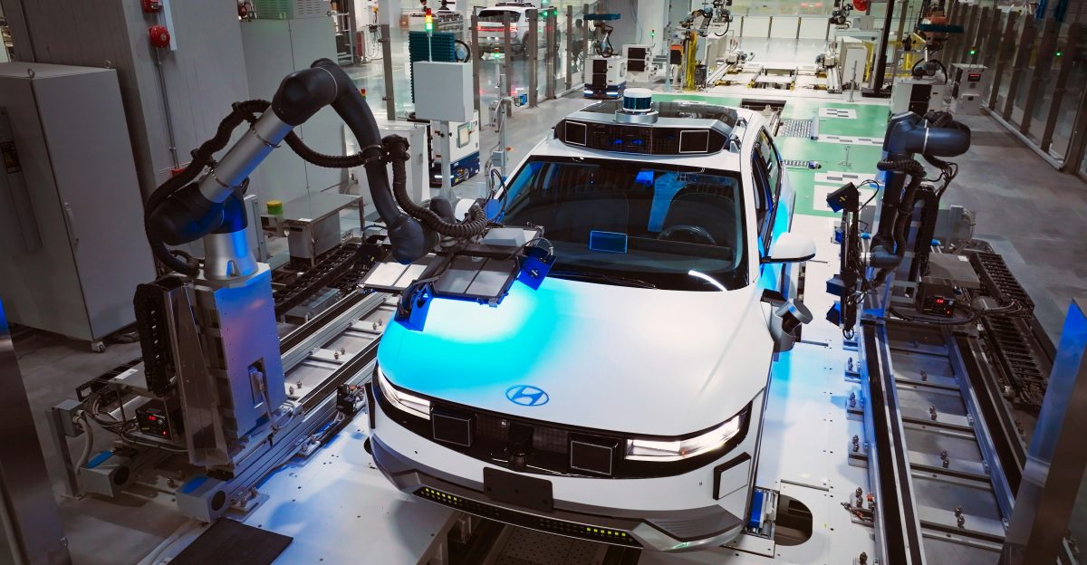 a white car is on a assembly line