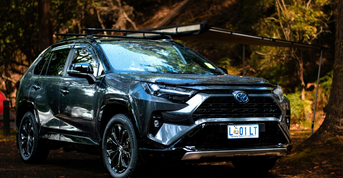 a black toyota rav parked in the woods