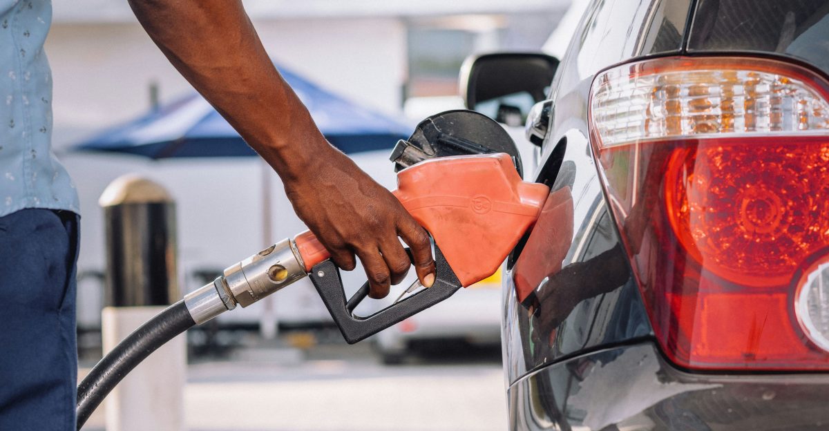 a man pumping gas into his car at a gas station
