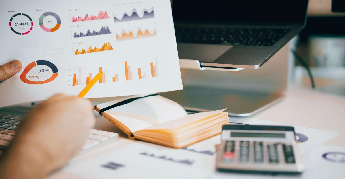 a person holding a piece of paper over a laptop