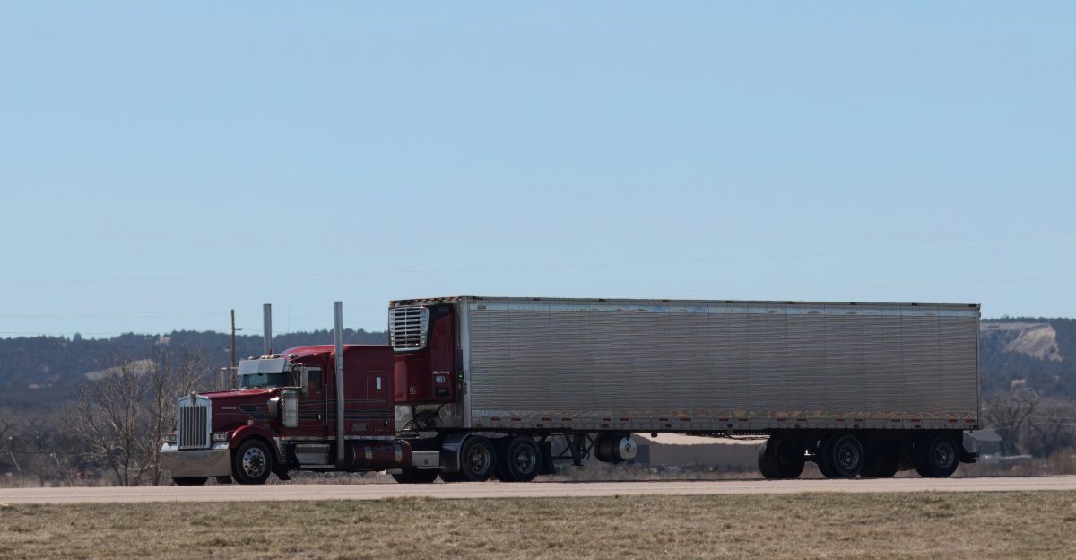 A large semi truck driving down a highway