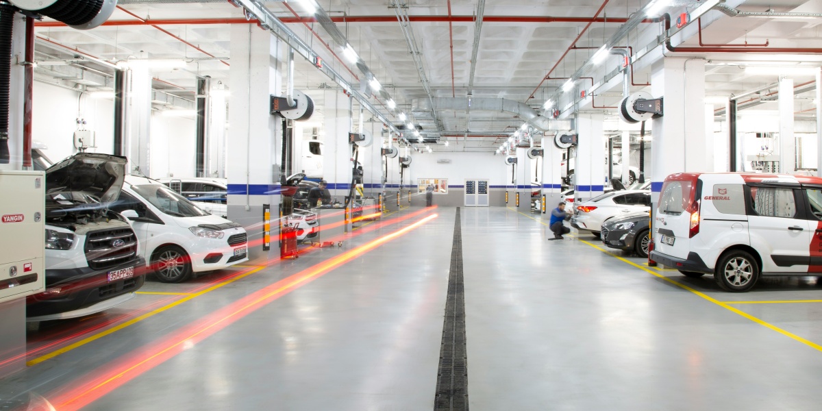 A large warehouse with many cars parked in it