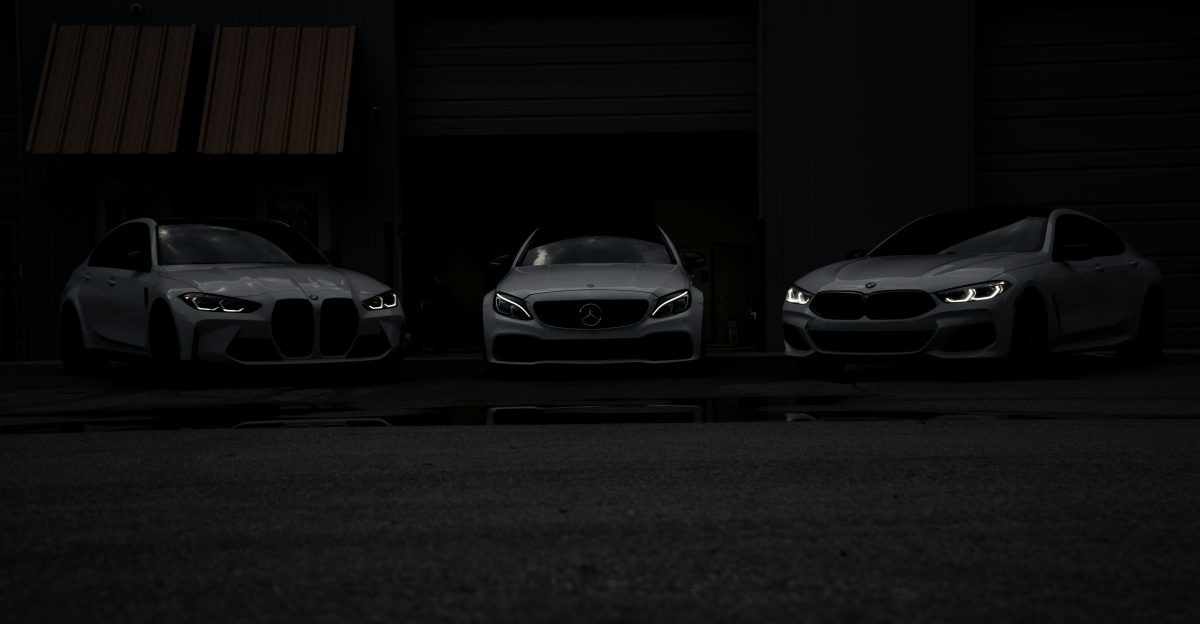 Three cars parked in front of a building at night