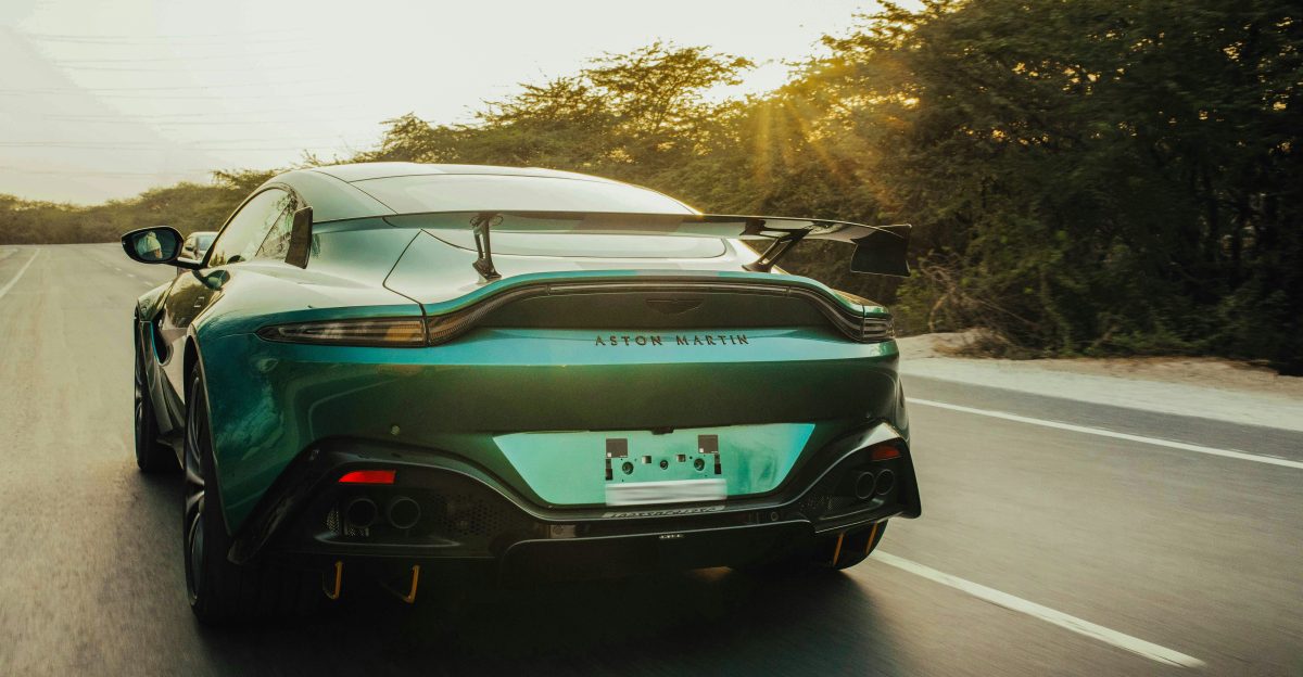 A green sports car driving down a road