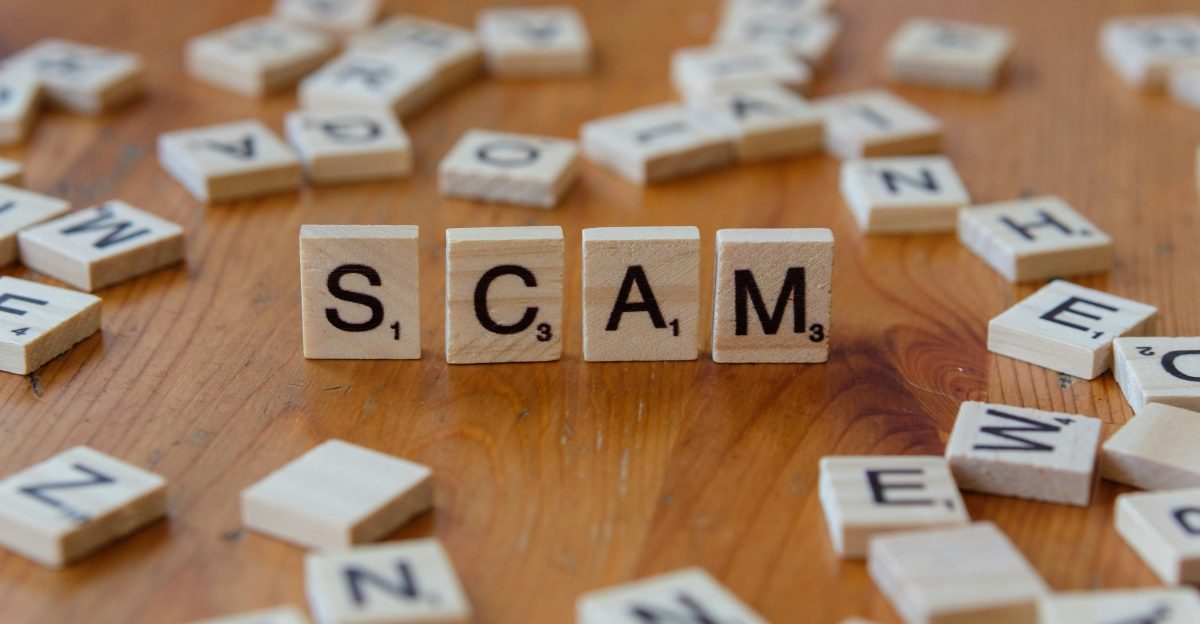 Scam spelled with scrabbles on a wooden table