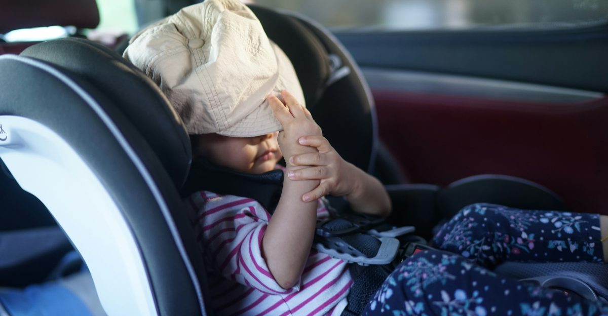 A child has a bag over their head in car