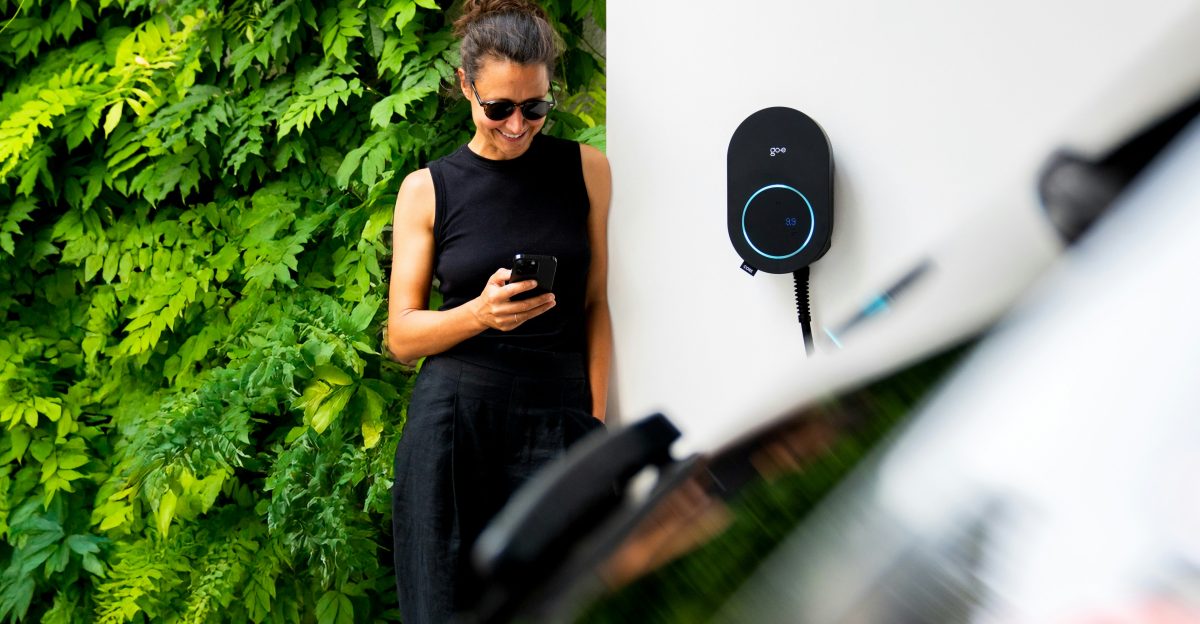 Woman using phone near electric car charger