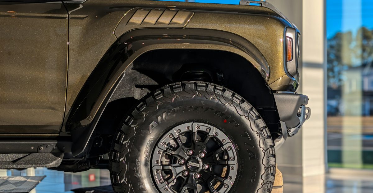 A close-up of a bronze suv s tire and fender