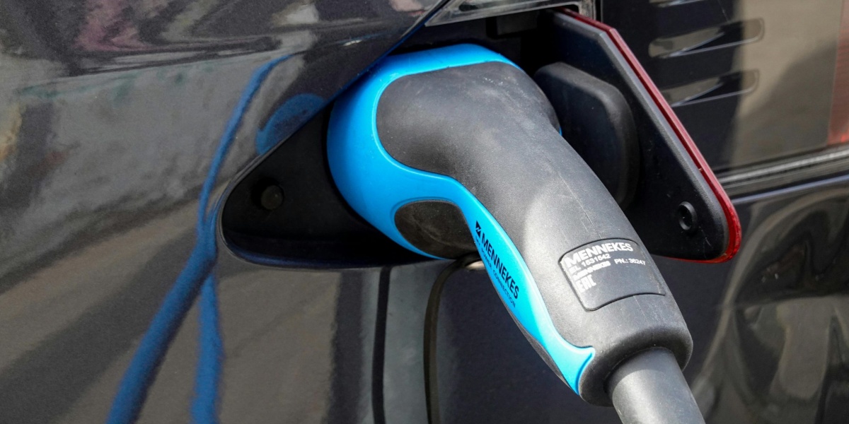 Close-up of an electric vehicle being charged using a Mennekes EV connector.