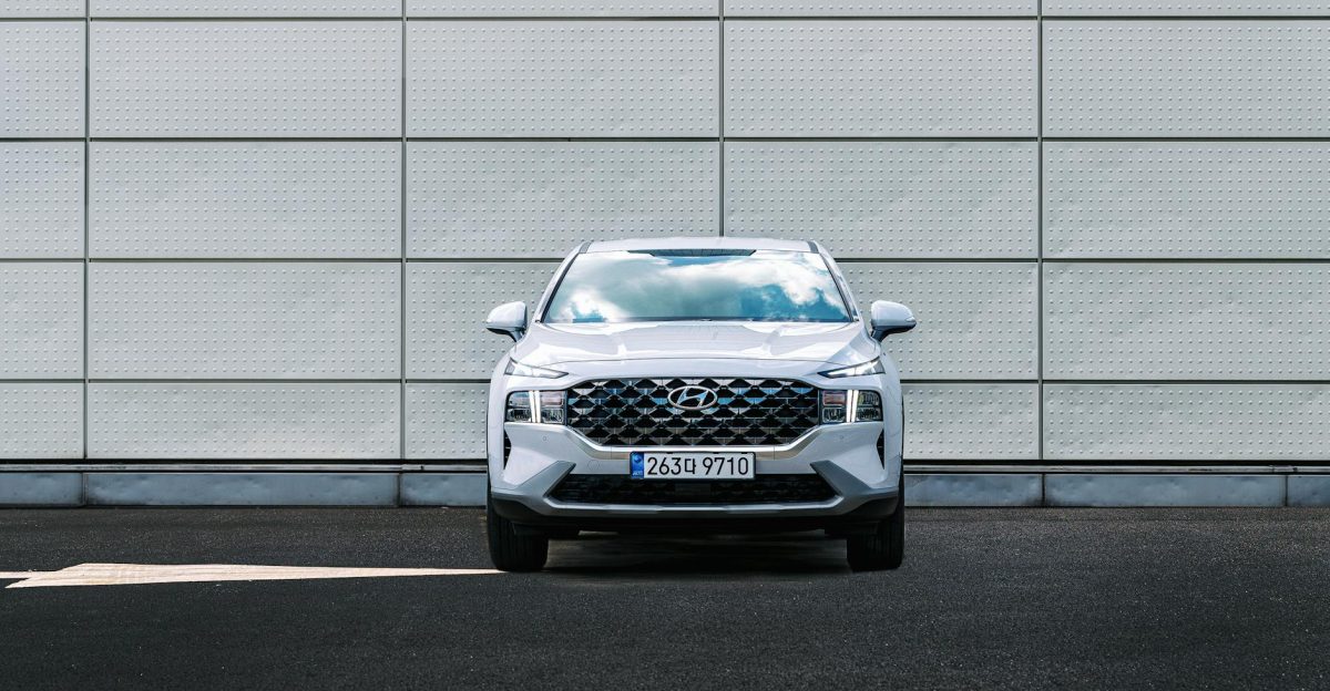 Front view of a Hyundai Santa Fe parked against a geometric urban wall design showcasing its exterior