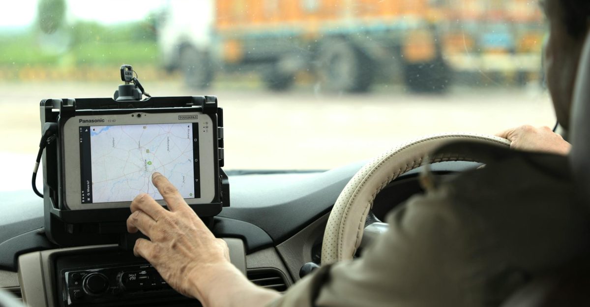 Police officer navigates using a digital map on a tablet inside a vehicle