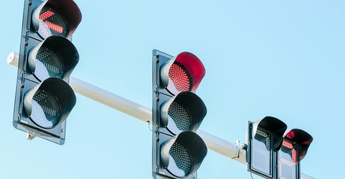 Traffic lights showing red against a clear blue sky on a sunny day