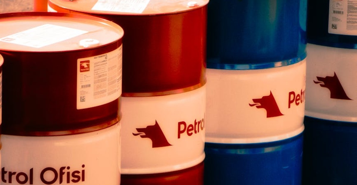 A collection of red and blue oil barrels labeled Petrol Ofisi in an outdoor industrial setting in Turkey
