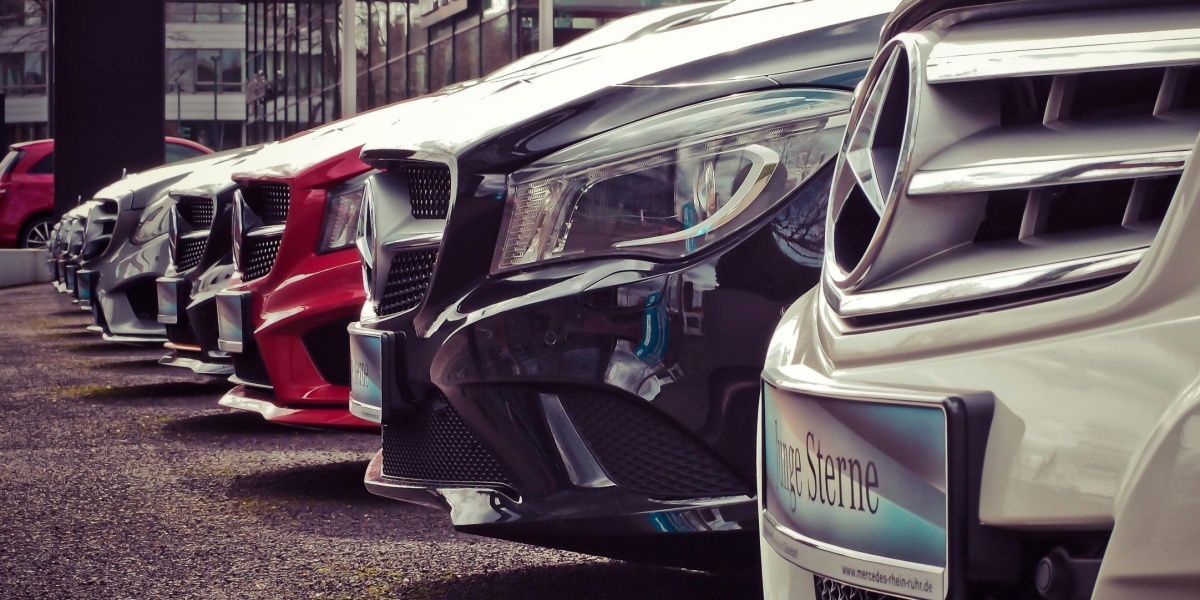 Luxury cars lined up at an outdoor dealership, showcasing sleek designs.