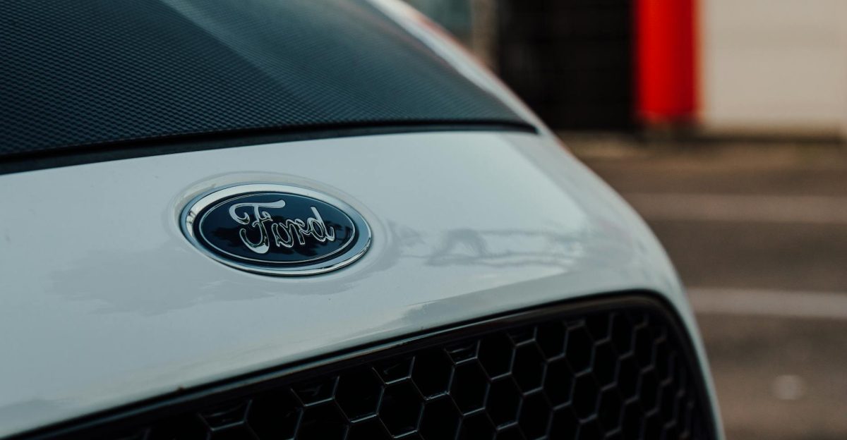 Detailed close-up image showcasing a white Ford car emblem on the vehicle s grille