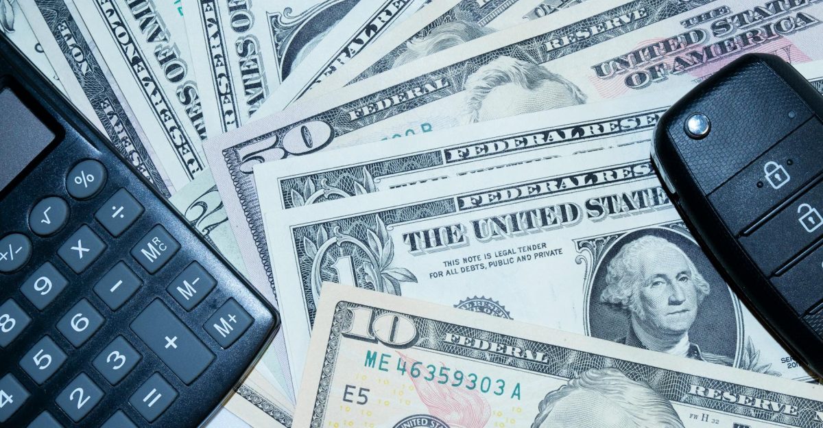 US dollars calculator and car keys representing finance and investment tools