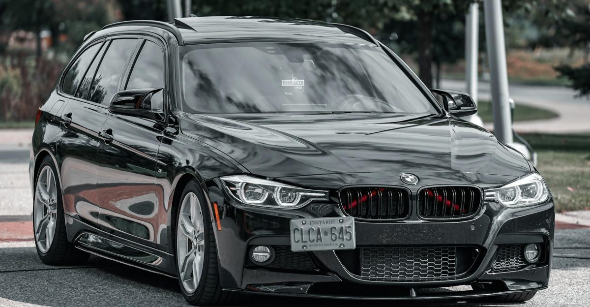 Luxury black sedan with sleek design parked on a city street during daytime