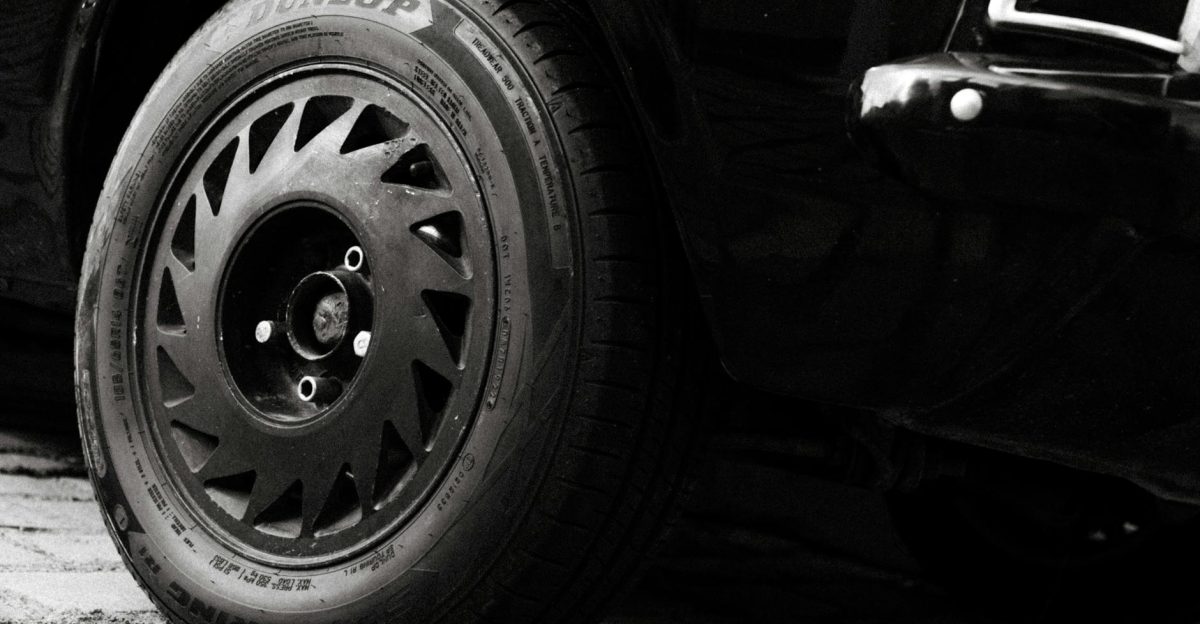 Detailed monochrome shot of a black sports car wheel displaying intricate design