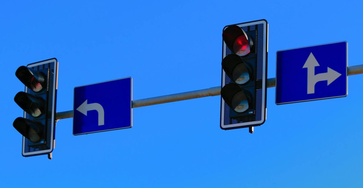 Traffic lights and directional road signs on a clear day with blue skies