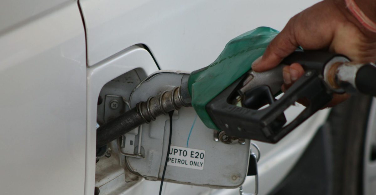 Hand refueling car with E20 petrol at a gas station close-up view