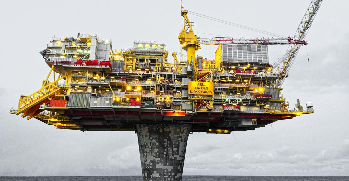 A well-lit offshore oil platform against a cloudy sky in Norway s waters