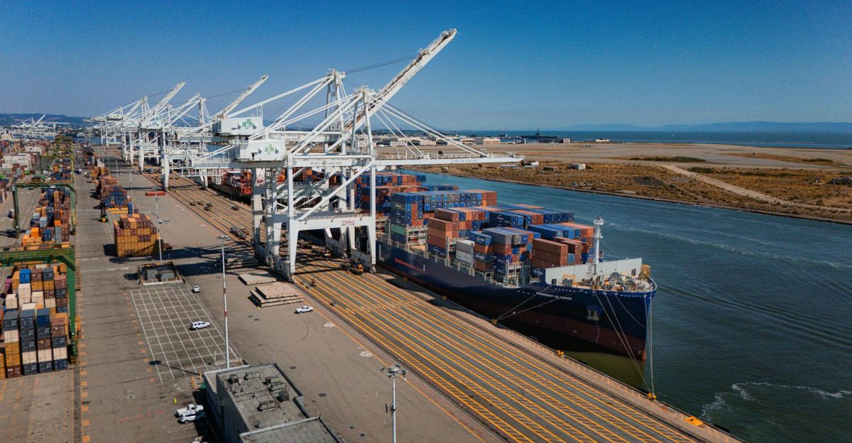Aerial view of cargo ship and containers at Port of Oakland under clear skies