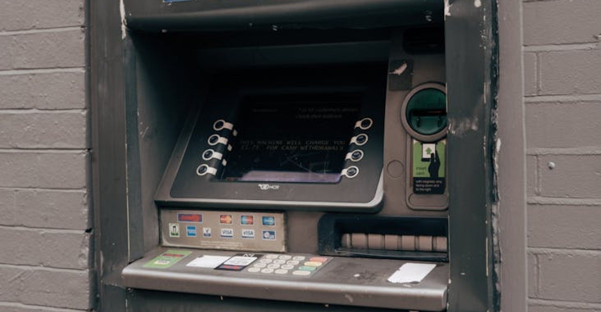 Vintage ATM machine embedded in a brick wall with worn exterior