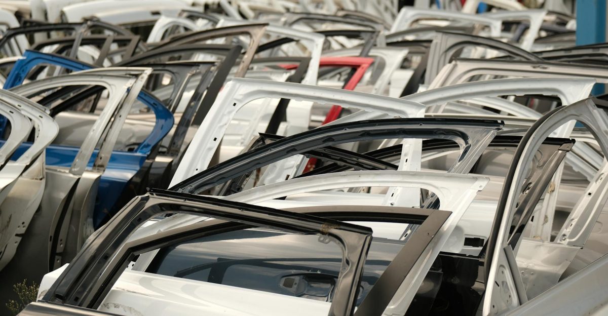 A variety of car doors in different colors arranged in a junkyard setting