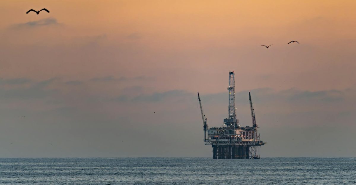 Oil platform silhouetted against a vibrant sunset in Huntington Beach California