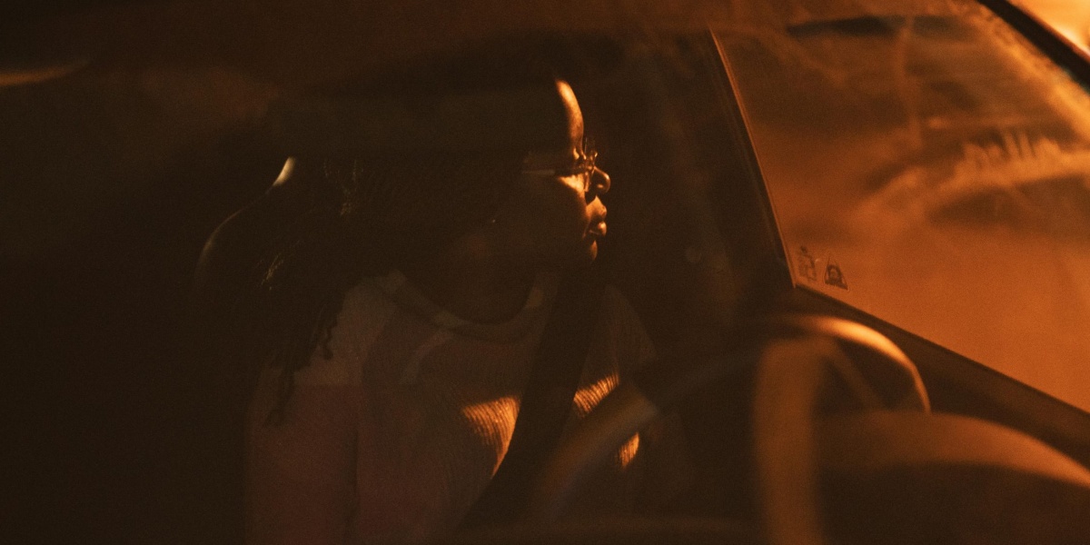 A woman driving at night in Kilamba, showcasing a serene and focused expression.