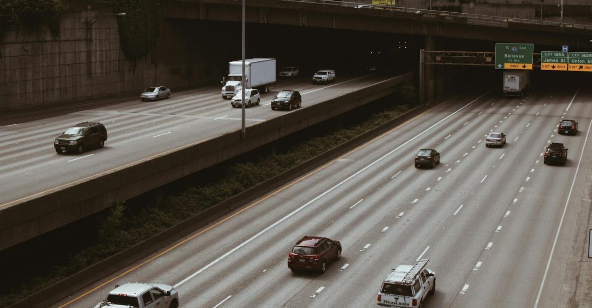 Cars and trucks on a highway in Seattle with visible signage and overpass