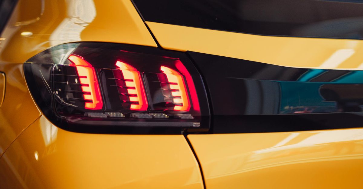 Bright and glossy close-up of a modern car taillight in a showroom setting